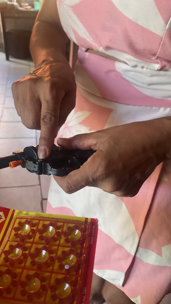 Cliente colocando as espoletas no revólver de brinquedo em casa.